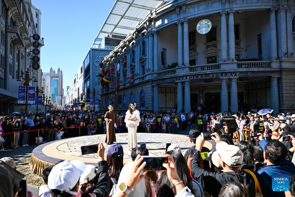 People watch a segment of a stage drama at a commercial street in north China's Tianjin, Oct. 6, 2026. During the National Day holiday, a special event of the 2026 Tianjin Theatre Festival unfolded across the city. Streets and alleys, century-old buildings and other cultural landmarks were transformed into open-air stages, presenting visitors with a feast of drama. (Xinhua/Zhao Zishuo)