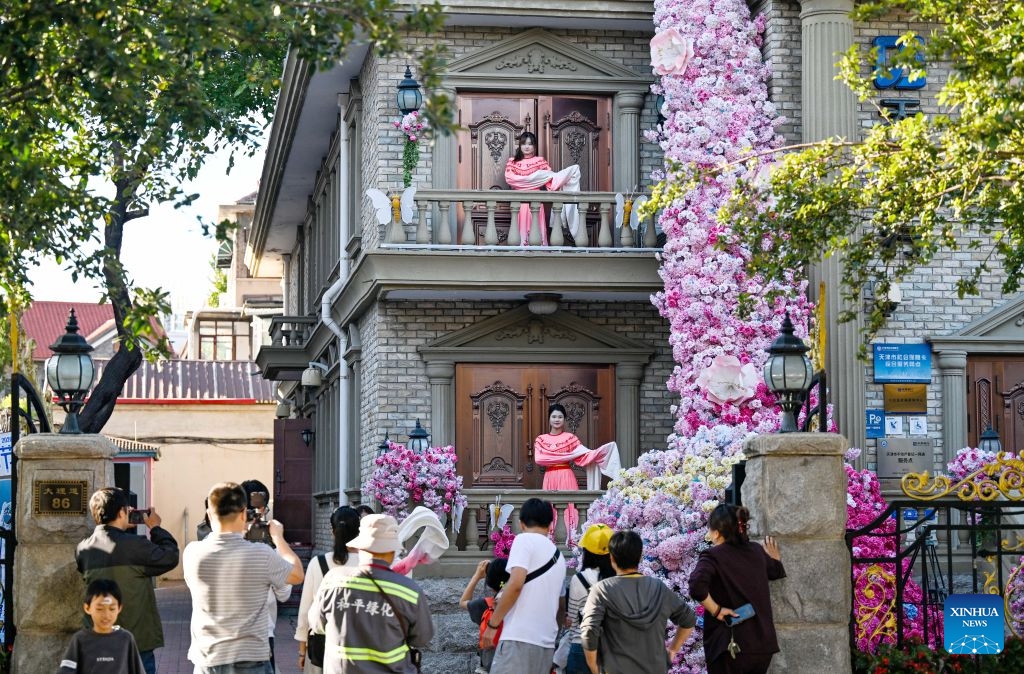 People watch a performance in Heping District, north China's Tianjin, Oct. 6, 2026. During the National Day holiday, a special event of the 2026 Tianjin Theatre Festival unfolded across the city. Streets and alleys, century-old buildings and other cultural landmarks were transformed into open-air stages, presenting visitors with a feast of drama. (Xinhua/Zhao Zishuo)