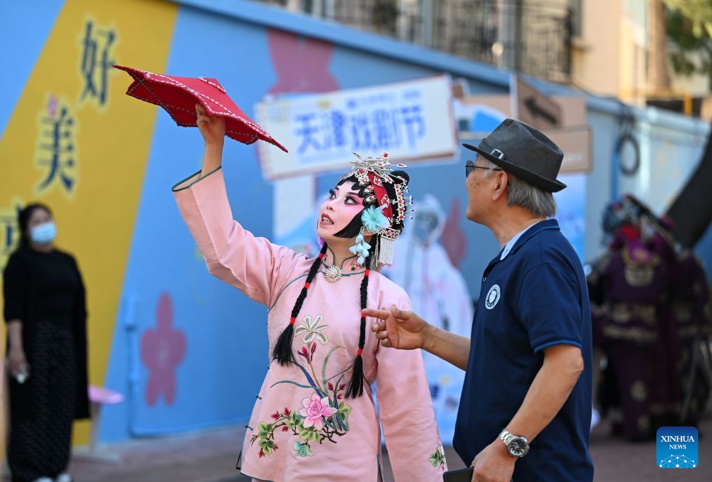 A performer interacts with a visitor in Heping District, north China's Tianjin, Oct. 6, 2026. During the National Day holiday, a special event of the 2026 Tianjin Theatre Festival unfolded across the city. Streets and alleys, century-old buildings and other cultural landmarks were transformed into open-air stages, presenting visitors with a feast of drama. (Xinhua/Zhao Zishuo)