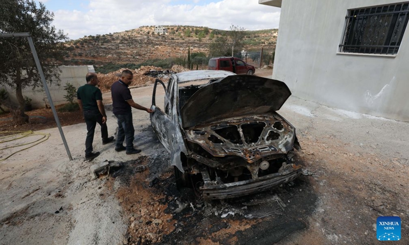 Palestinians inspect a vehicle burnt by Israeli settlers in the village of Aqraba, south of Nablus, in the West Bank, Oct. 6, 2026. Photo: Xinhua