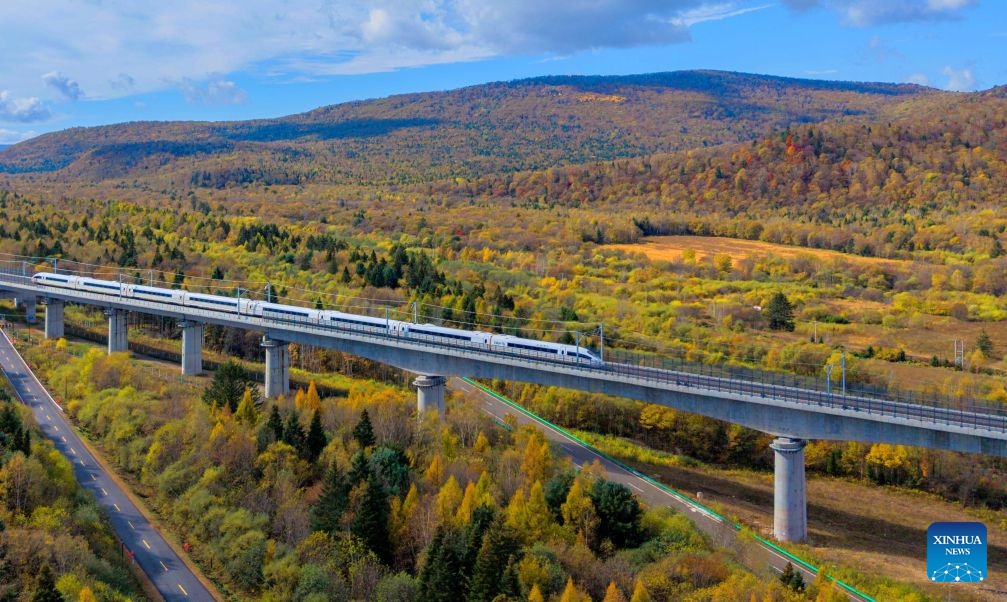 An aerial drone photo taken on Sept. 30, 2026 shows a bullet train of Harbin-Yichun high-speed railway running through forests in autumn scenery in Yichun, northeast China's Heilongjiang Province. The Harbin-Yichun high-speed railway, China's northernmost high-speed railway which officially entered service on Sept. 28, underlines the country's efforts to direct more transport infrastructure investment toward border areas, forest regions and less-developed regions, while helping boost development and prosperity in northeast China's border regions. (Photo by Li Jiaxing/Xinhua)