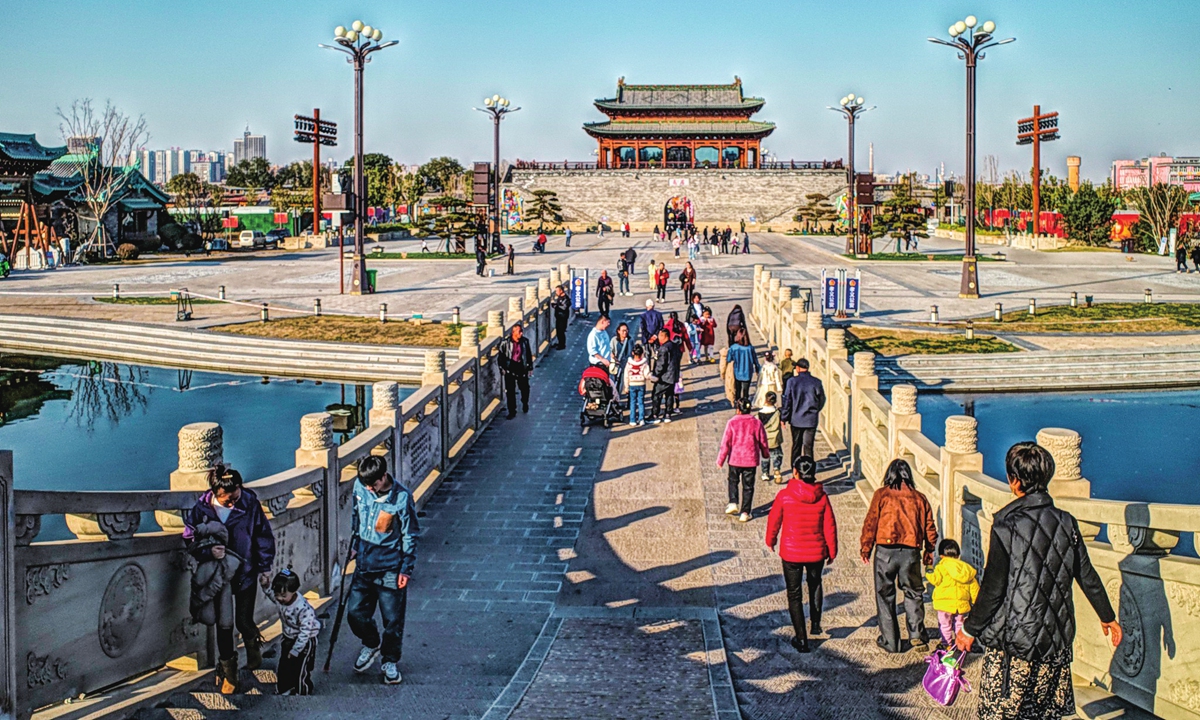 Tourists walk toward the ancient gate tower in Xiaoyi Ancient City, North China's Shanxi Province, on November 2, 2025.