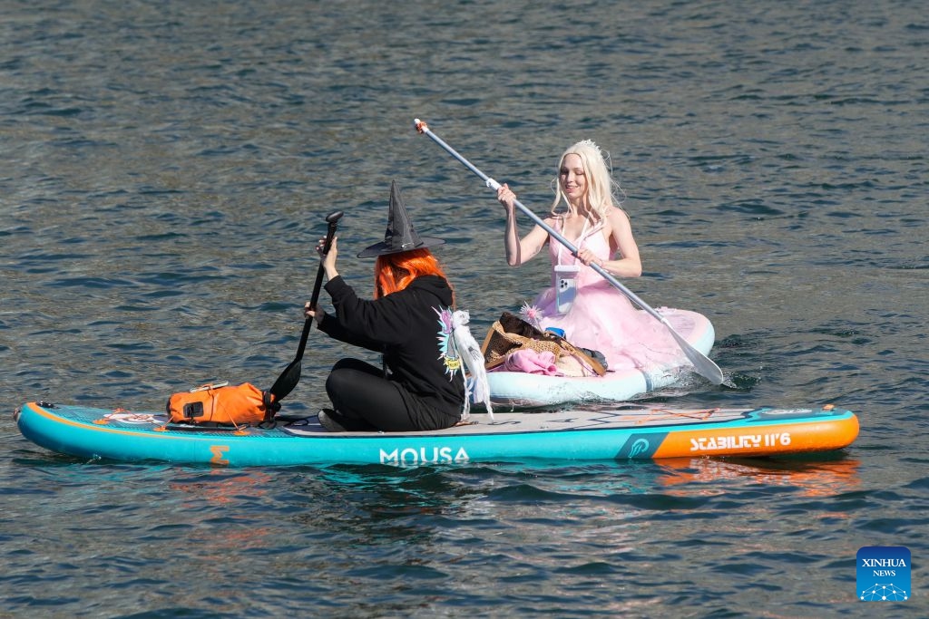 Participants dressed as witches paddle along the waterfront during the 6th Witchilano Paddle in Vancouver, British Columbia, Canada, Oct. 3, 2026. The annual event took place on Saturday, bringing together hundreds of costumed paddlers to celebrate the upcoming Halloween on the water. (Photo by Liang Sen/Xinhua)