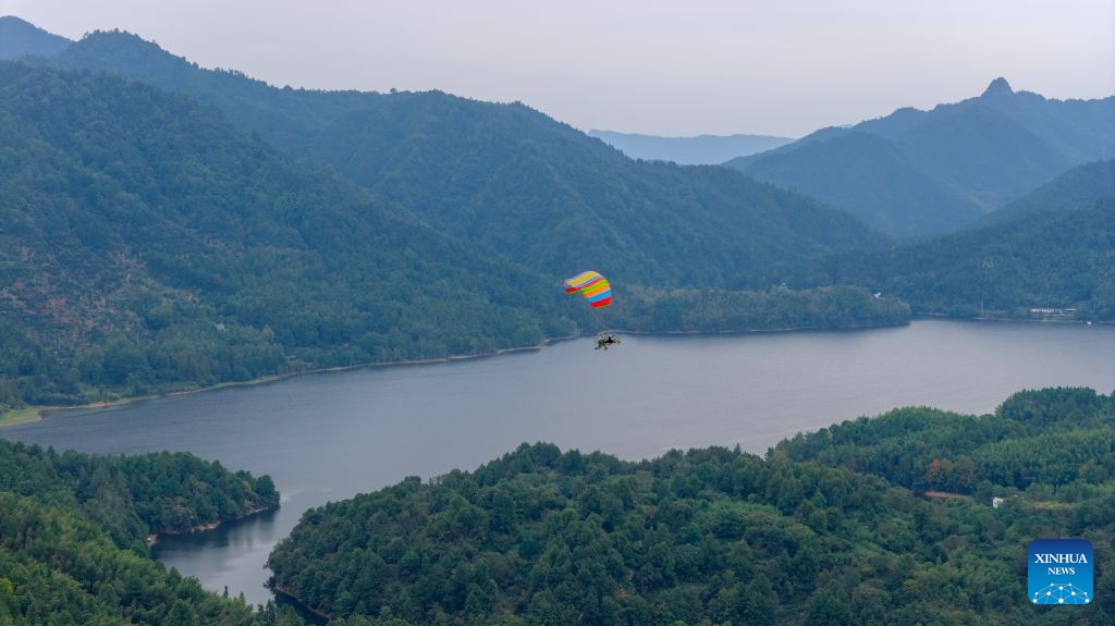 An aerial drone photo taken on Oct. 5, 2026 shows tourists enjoying powered paragliding in Hongcun Village of Yixian County, Huangshan City, east China's Anhui Province.  (Photo by Fan Chengzhu/Xinhua)