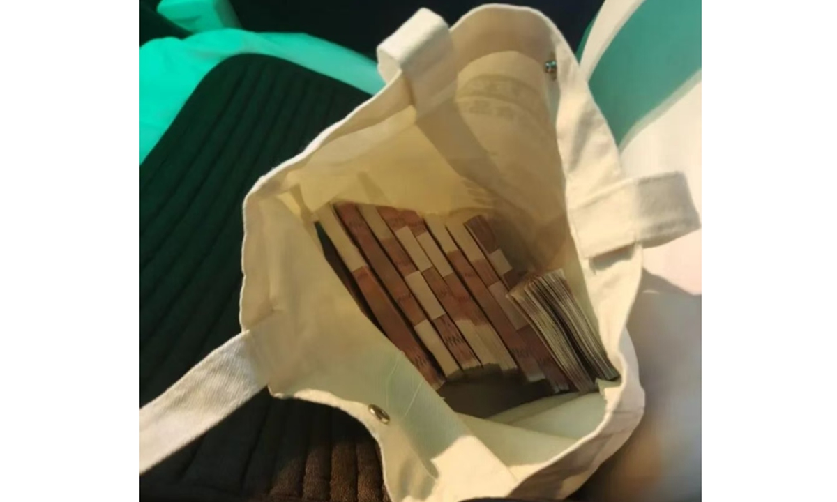 The bag containing 100,000 yuan in cash, which belongs to the passenger surnamed Shang, was left on the back seat of taxi driver Qi Jianfu's vehicle. Photo: Dahe.cn