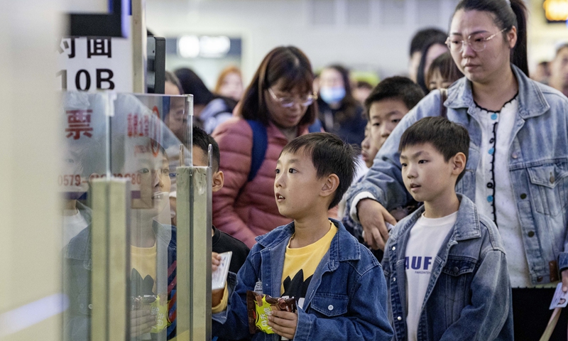 Students wait with their parents to board a train for an autumn holiday trip in Jinhua, East China’s Zhejiang Province on November 12, 2025. Photo: VCG