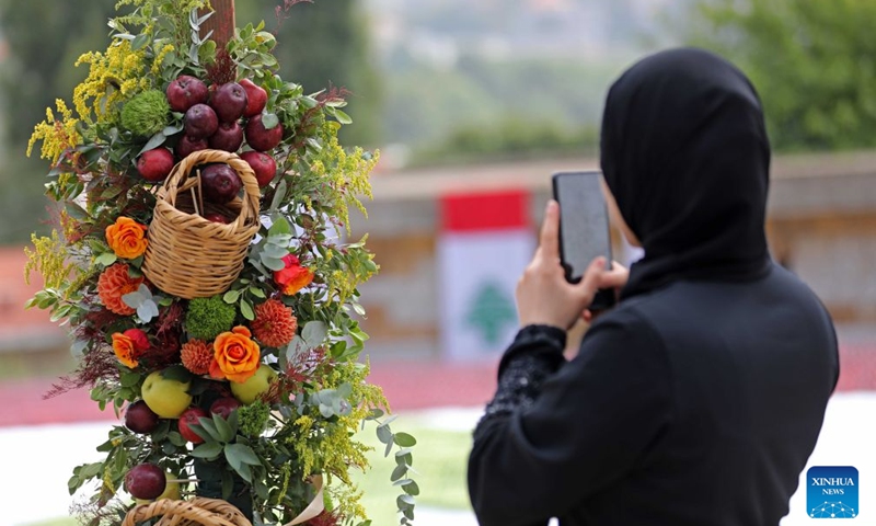 A visitor takes photos during an apple festival in the village of Baskinta, Lebanon, Oct. 10, 2026. (Xinhua/Bilal Jawich)