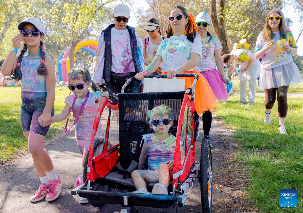 People attend a color run event in Canberra, Australia, Oct. 11, 2026. (Photo by Chu Chen/Xinhua)

