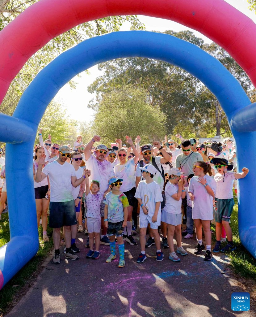 People participate in a color run event in Canberra, Australia, Oct. 11, 2026. (Photo by Chu Chen/Xinhua)

