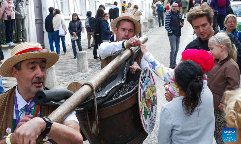 Parade participants hand out grapes to spectators during the Montmartre Grape Harvest Festival in Paris, France, Oct. 10, 2026. The 93rd edition of the Montmartre Grape Harvest Festival runs from Oct. 7 to 11, featuring a grand parade, musical performances and other festivities. (Xinhua/Wu Huiwo)