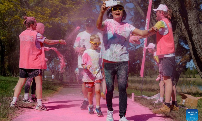 People participate in a color run event in Canberra, Australia, Oct. 11, 2026. (Photo by Chu Chen/Xinhua)


