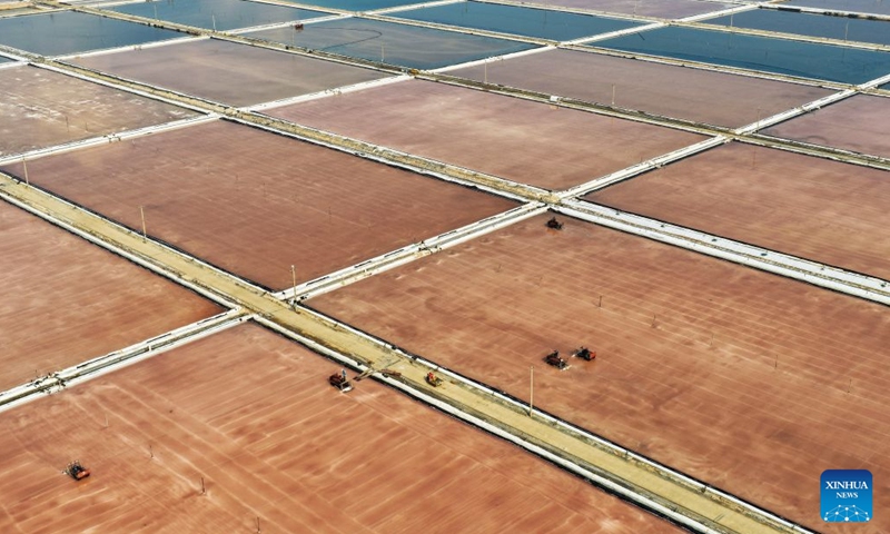 An aerial drone photo taken on Oct. 10, 2026 shows workers operating in salt fields in Lianyungang City, east China's Jiangsu Province. Autumn salt harvest is underway in coastal salt fields in Lianyungang. (Photo by Wang Jianmin/Xinhua)

