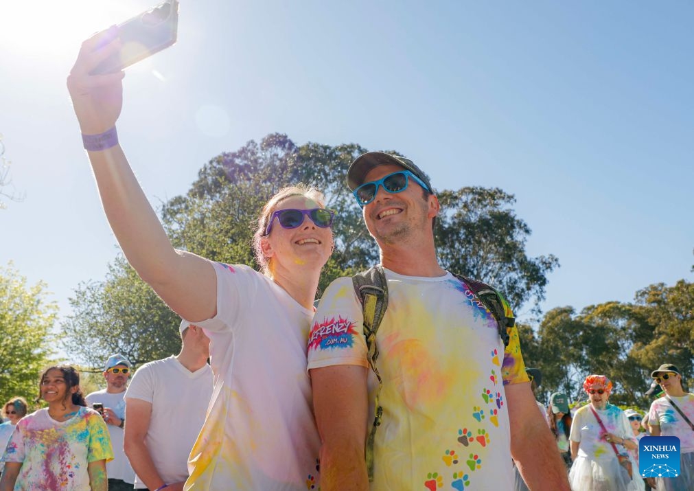 People take a selfie during a color run event in Canberra, Australia, Oct. 11, 2026. (Photo by Chu Chen/Xinhua)

