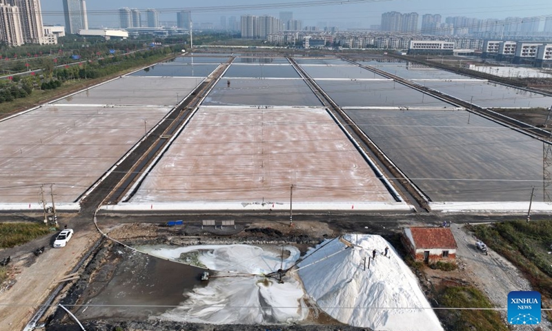 A drone photo taken on Oct. 11, 2026 shows workers operating in a salt field in Lianyungang City, east China's Jiangsu Province. Autumn salt harvest is underway in coastal salt fields in Lianyungang. (Photo by Wang Chun/Xinhua)

