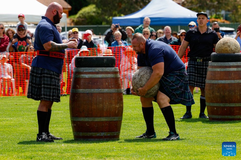 A competitor takes part in the stone-lifting competition during the Canberra Highland Gathering in Canberra, Australia, on Oct. 10, 2026. The Scottish cultural event featuring traditional sports, bagpipe and drum performances, dance and traditional food was held in Canberra on Saturday. (Photo by Chu Chen/Xinhua)