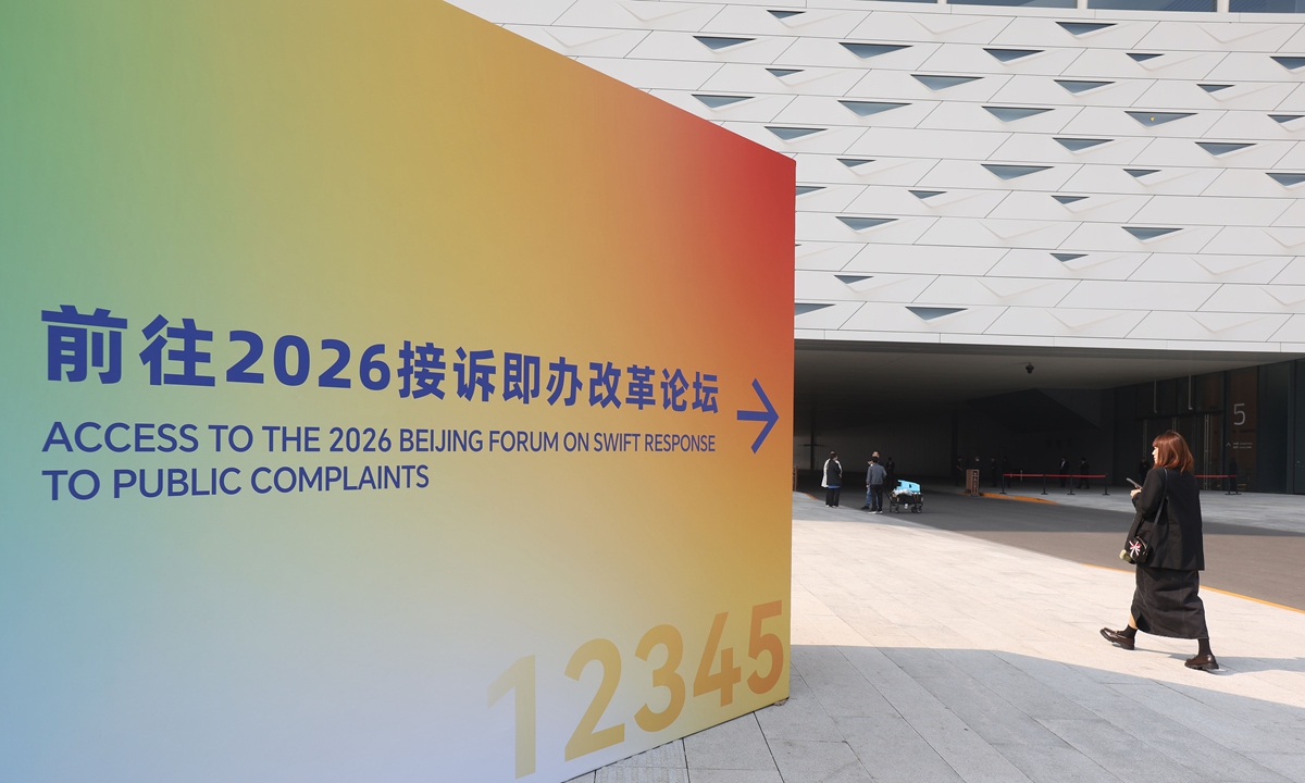 A visitor walks past a sign for the 2026 Beijing Forum on Swift Response to Public Complaints in Beijing on October 12, 2026. The forum opened that day under the annual theme 