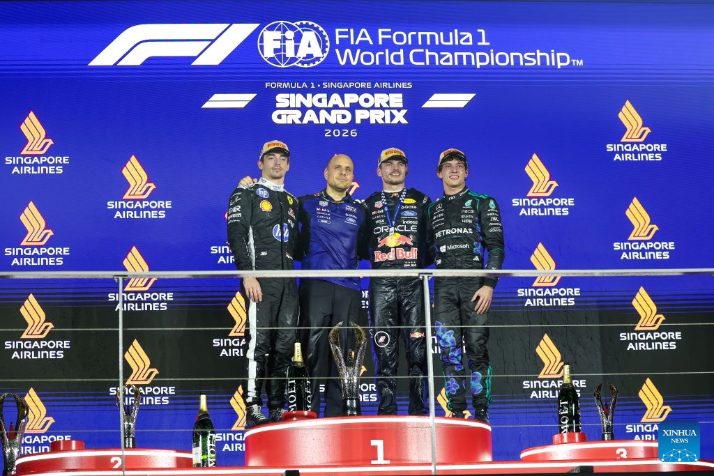 Race winner Red Bull's Max Verstappen (2nd R) of the Netherlands, 2nd place Ferrari's Charles Leclerc (1st L) of Monaco and 3rd place Mercedes' Kimi Antonelli (1st R) of Italy pose for photos on the podium after the Formula One Singapore Grand Prix at the Marina Bay Street Circuit in Singapore, on Oct. 11, 2026. (Photo by Qian Jun/Xinhua)