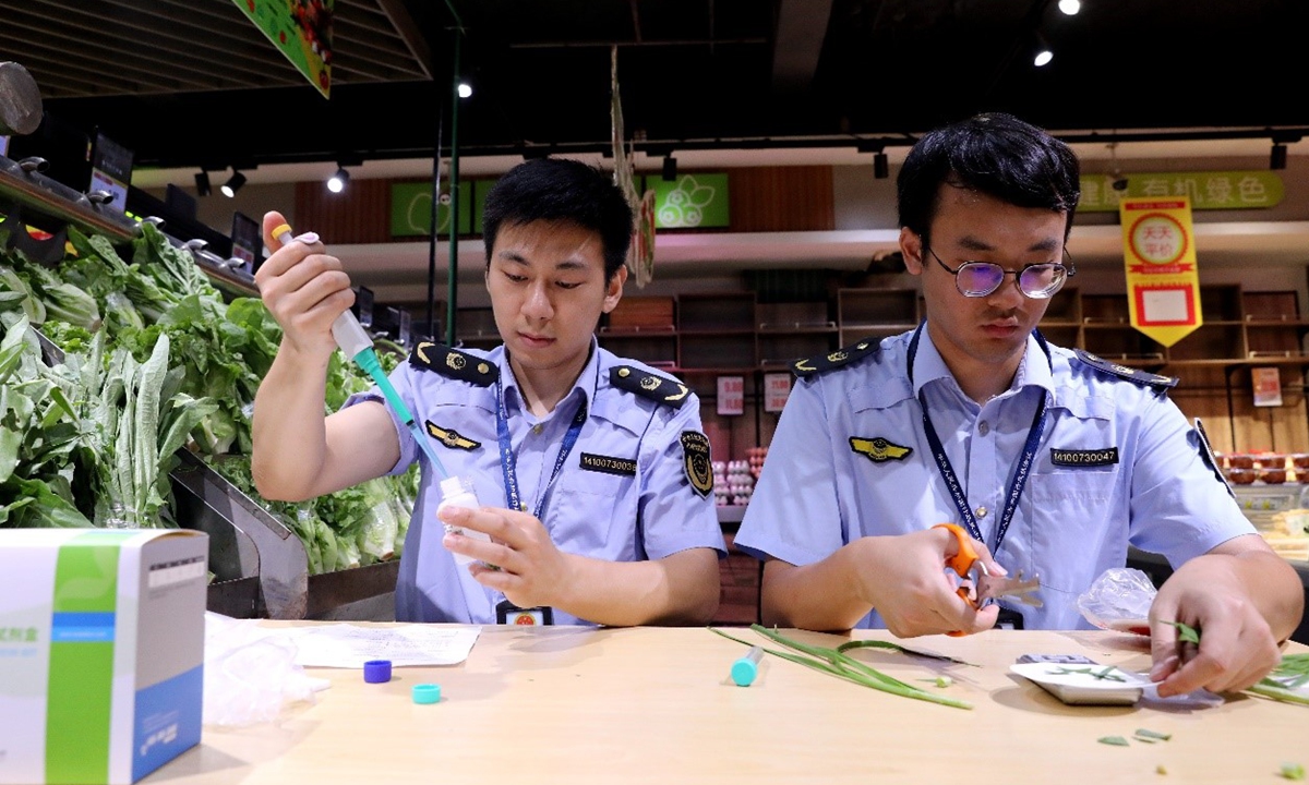Staff members from the Xiajiang County Administration for Market Regulation conduct tests on vegetables sold at a supermarket in Xiajiang county, East China's Jiangxi Province, on September 22, 2026. Photo: VCG