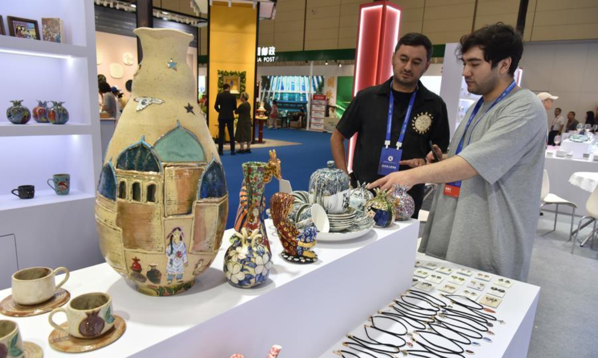An exhibitor introduces Kyrgyz porcelain works during the 2026 China Jingdezhen International Ceramic Expo in Jingdezhen, east China's Jiangxi Province, Oct. 18, 2026. (Photo by Shi Weiming/Xinhua)