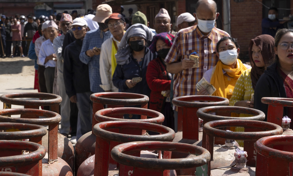 Nepali people line up with empty cooking gas cylinders while waiting for supplies in Kathmandu on October 13, 2026. Nepal is facing a cooking gas shortage as recent flash floods and landslides have disrupted transport. Photo: VCG