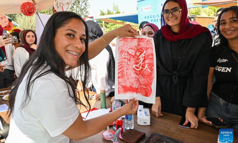A visitor experiences Chinese rubbing during a Chinese culture festival at Badr University in Cairo, Egypt, Oct. 12, 2026. A Chinese culture festival was held Monday at Badr University in Cairo to celebrate the 70th anniversary of the establishment of diplomatic relations between China and Egypt, featuring cultural performances, traditional Chinese arts and student exchanges. (Photo: Xinhua)