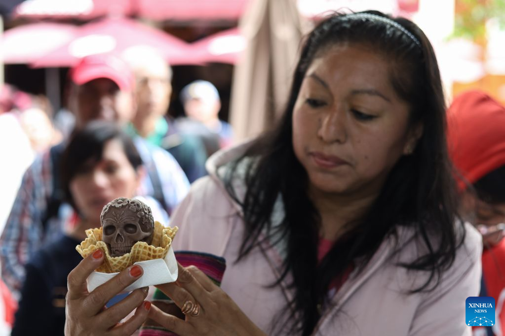 A customer holds a Catrina-shaped ice cream in Mexico City, capital of Mexico, Oct. 17, 2026. As the Day of the Dead approaches, an ice cream shop in Mexico City has introduced Catrina-shaped ice creams, attracting many local residents and tourists. (Photo by Francisco Canedo/Xinhua)