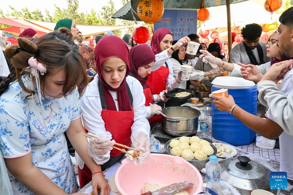Students prepare Chinese snacks for visitors during a Chinese culture festival at Badr University in Cairo, Egypt, Oct. 12, 2026. A Chinese culture festival was held Monday at Badr University in Cairo to celebrate the 70th anniversary of the establishment of diplomatic relations between China and Egypt, featuring cultural performances, traditional Chinese arts and student exchanges. (Photo: Xinhua)