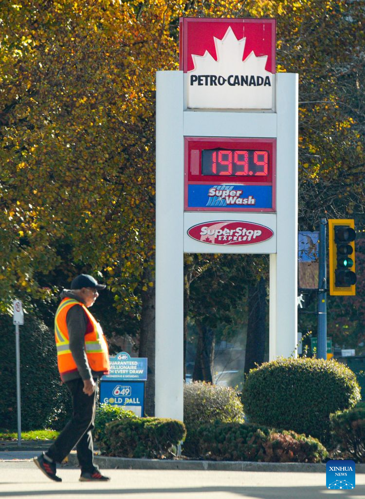 A gas station staff worker walks past a gas price display in Vancouver, British Columbia, Canada, on Oct. 19, 2026. Canada's Consumer Price Index (CPI) rose 3.1 percent year over year in September, following a 3-percent increase in August, Statistics Canada said Monday. (Photo by Liang Sen/Xinhua)