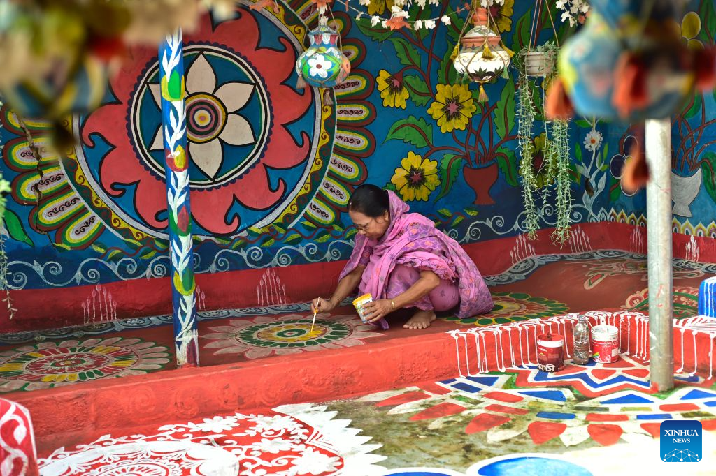 A woman paints Alpona in a village in Chapainawabganj District, Bangladesh, Oct. 18, 2026. Alpona is a traditional form of folk art practiced in South Asia and is mainly created by women in the local community. (Photo by Habibur Rahman/Xinhua)