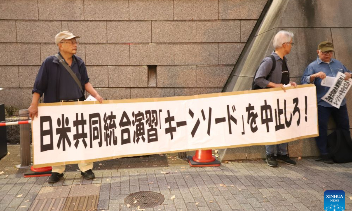 People holding signs attend a protest rally in Tokyo, Japan, Oct. 20, 2026. Japanese citizens staged a protest rally in front of the Ministry of Defense in Tokyo on Tuesday evening, opposing the large-scale Japan-U.S. joint military exercises and the military buildup. (Xinhua/Li Ziyue)