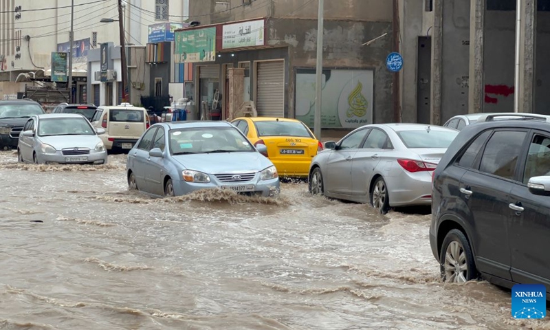 This photo taken with a mobile phone shows vehicles running on a flooded road after heavy rains in Tripoli, Libya, Oct. 13, 2026. (Photo: Xinhua)