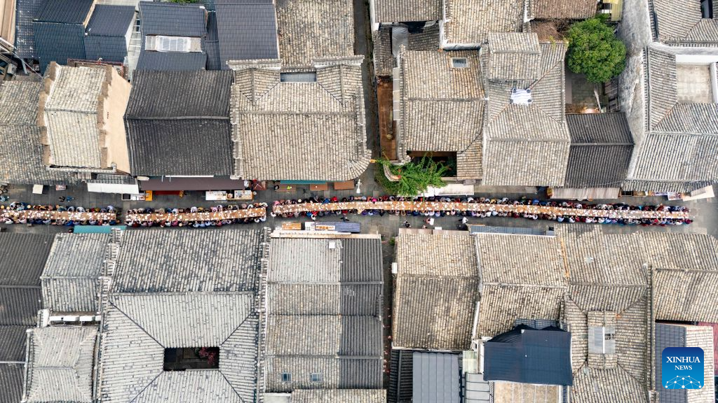 An aerial drone photo taken on Oct. 15, 2026 shows a view of a long-table banquet held for the elderly in Yanggang Village of Lanxi, east China's Zhejiang Province. Funded by kind-hearted people, the banquet held on Thursday was attended by more than 500 people aged 60 and above to mark the upcoming Double Ninth Festival. Celebrated on the ninth day of the ninth lunar month, it is an occasion to care for and send blessings to older people in China. (Photo by Hu Xiaofei/Xinhua)