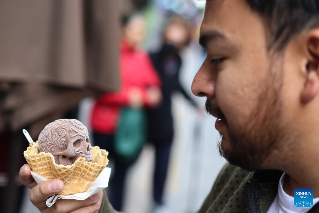 A man holds a Catrina-shaped ice cream in Mexico City, capital of Mexico, Oct. 17, 2026. As the Day of the Dead approaches, an ice cream shop in Mexico City has introduced Catrina-shaped ice creams, attracting many local residents and tourists. (Photo by Francisco Canedo/Xinhua)