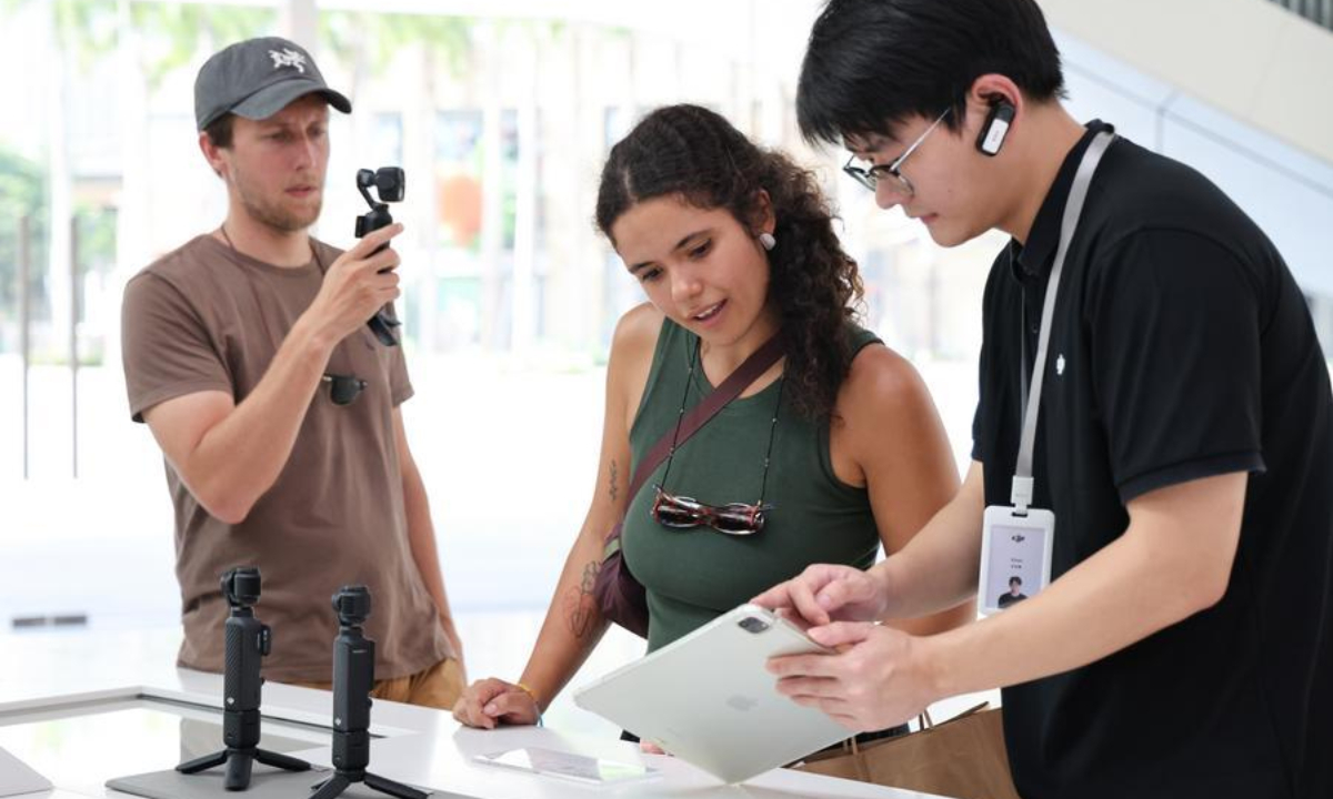 Foreign tourists buy handheld camera equipment at a flagship store of DJI in Shenzhen, south China's Guangdong Province, June 24, 2026. (Xinhua/Liang Xu)