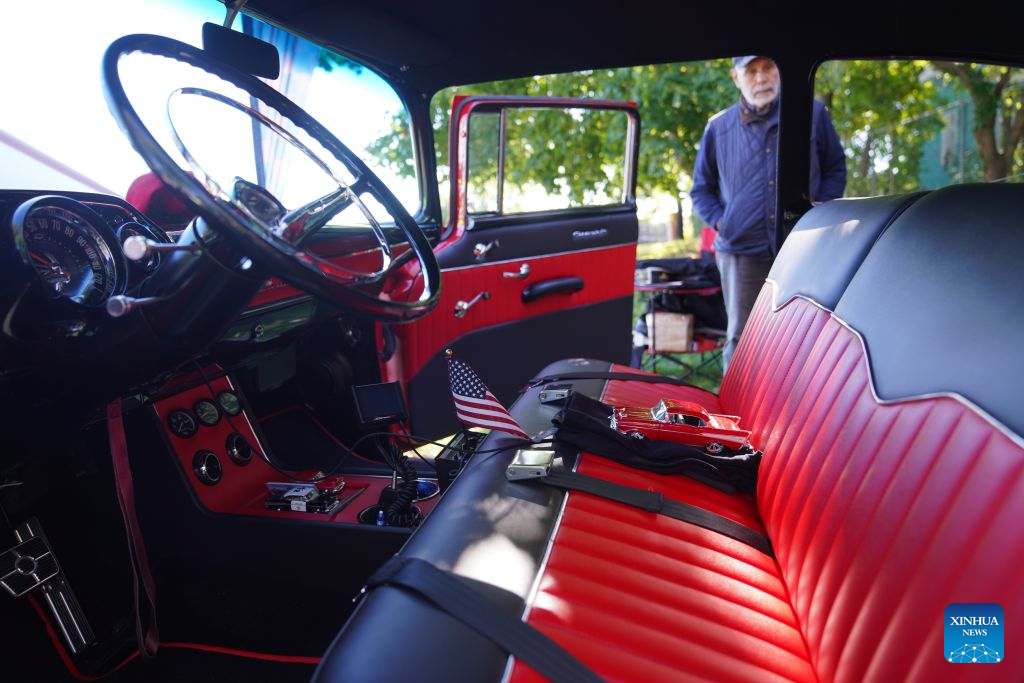 A man views an exhibit during a vintage car show at Fort Totten in New York, the United States, Oct. 18, 2026. An annual vintage car show to greet autumn was held here on Sunday. (Xinhua/Zhang Fengguo)