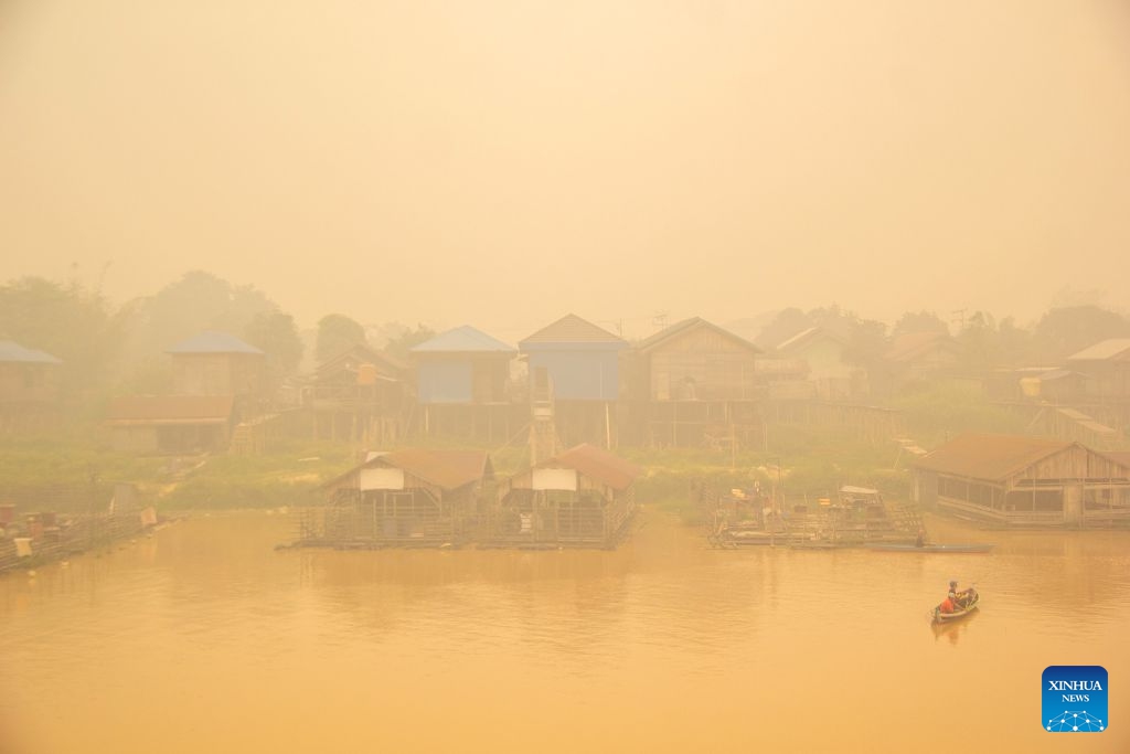 People take a boat amid thick haze caused by forest and peatland fires in Palangka Raya, Central Kalimantan, Indonesia, Oct. 12, 2026. (Photo: Xinhua)