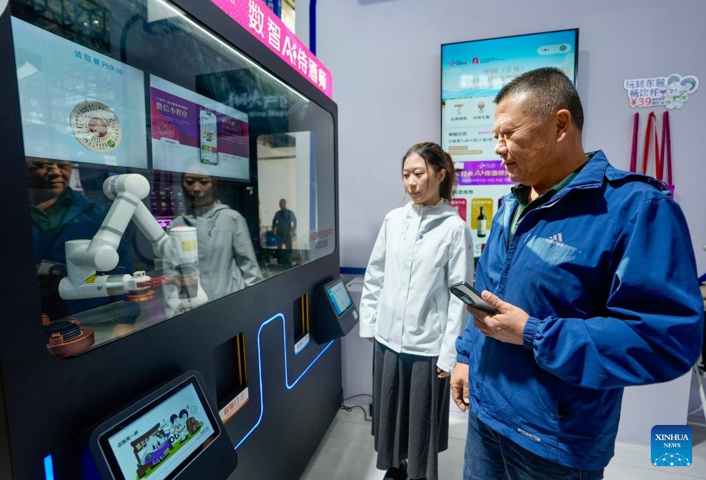 People experience the AI sommelier service at the sixth China (Ningxia) International Wine Culture and Tourism Expo in Yinchuan, northwest China's Ningxia Hui Autonomous Region, Oct. 13, 2026. (Photo: Xinhua)