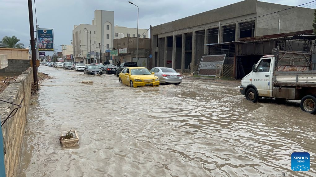 This photo taken with a mobile phone shows vehicles running on a flooded road after heavy rains in Tripoli, Libya, Oct. 13, 2026. (Photo: Xinhua)