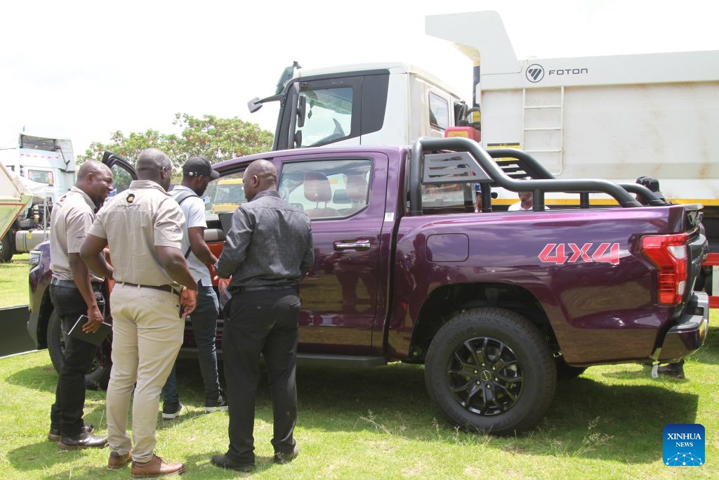 People view a vehicle on display at the China-Zimbabwe Commodity Expo and Job Fair in Harare, Zimbabwe, on Oct. 9, 2026. Chinese heavy-duty truck brands attracted strong interest from visitors at the three-day China-Zimbabwe Commodity Expo and Job Fair, which concluded Sunday in the Zimbabwean capital of Harare, reflecting growing local demand for reliable commercial vehicles. (Photo: Xinhua)