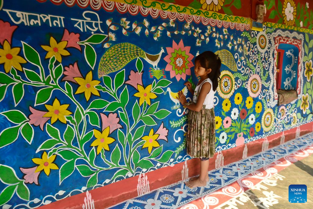 A child is seen at a house decorated with Alpona in a village in Chapainawabganj District, Bangladesh, Oct. 18, 2026. Alpona is a traditional form of folk art practiced in South Asia and is mainly created by women in the local community. (Photo by Habibur Rahman/Xinhua)
