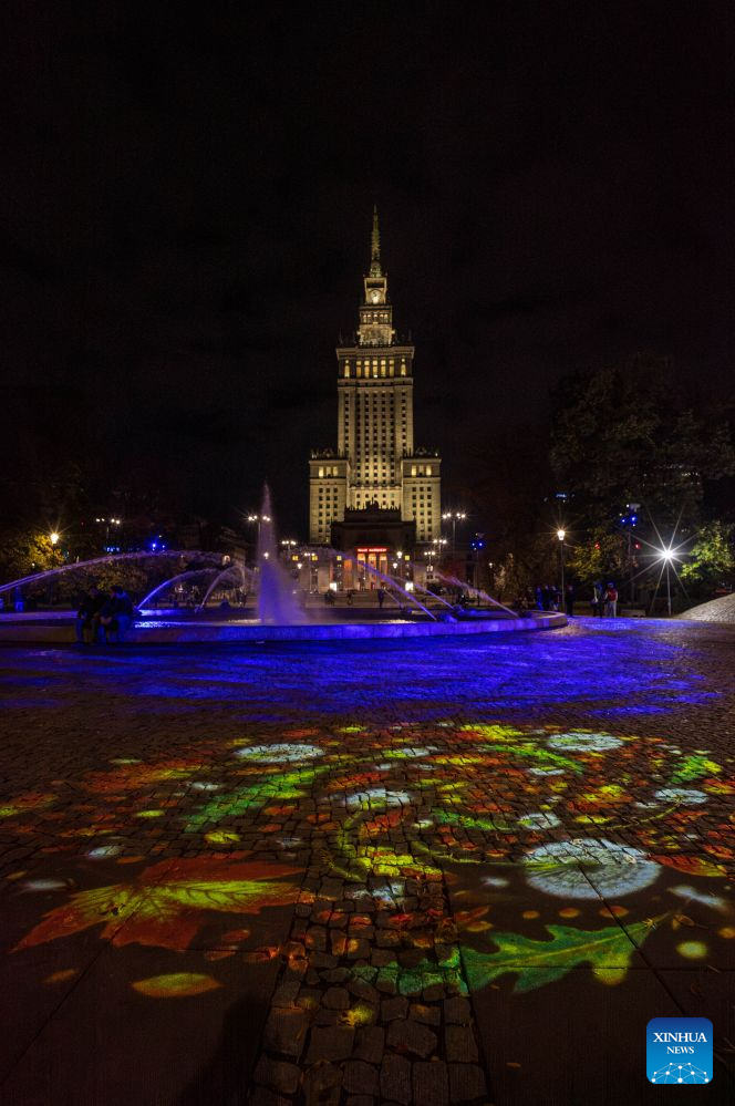 This photo taken on Oct. 15, 2026 shows an illuminated plant installation in a light garden in Swietokrzyski Park, with the Palace of Culture and Science in the background, in Warsaw, Poland. The year-round light garden opened on Thursday, featuring illuminated plant and butterfly installations and interactive projections that respond to visitors' movements. (Photo by Jaap Arriens/Xinhua)