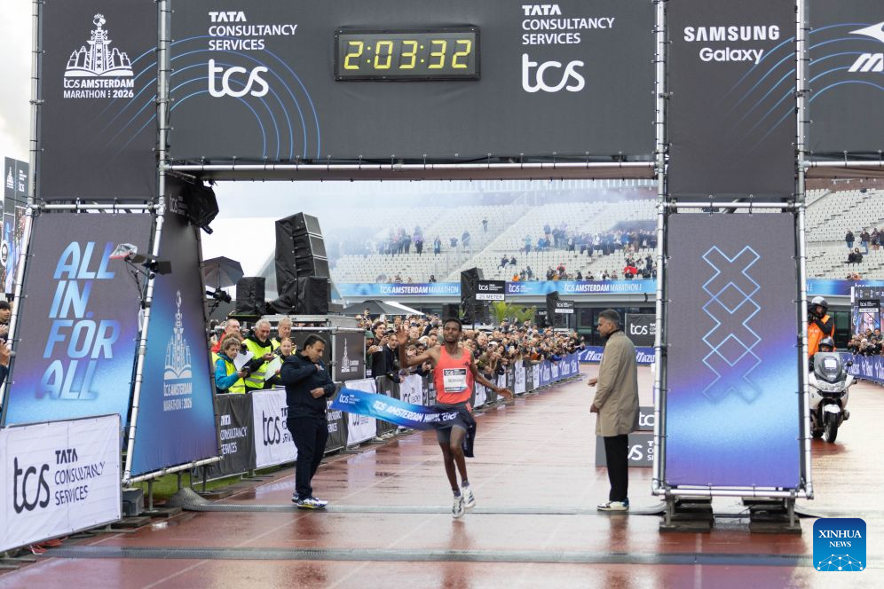 Lemi Berhanu (C) of Ethiopia crosses the finish line during the Amsterdam Marathon in Amsterdam, the Netherlands, Oct. 18, 2026. (Photo by Sylvia Lederer/Xinhua)