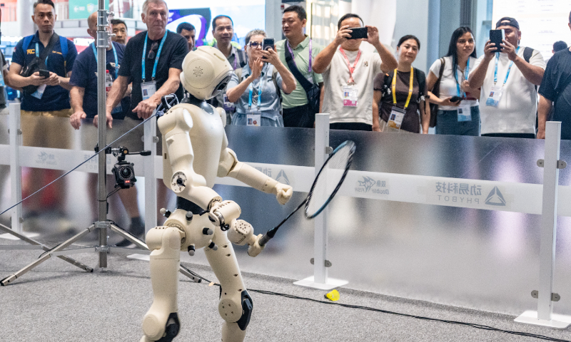 Global buyers watch and film a China-made robot playing badminton at the 140th Canton Fair in Guangzhou, South China's Guangdong Province, on October 15, 2026. Photo: VCG