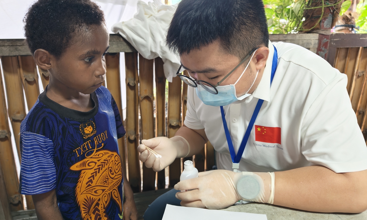 A Chinese doctor talks to a child in Papua New Guinea.