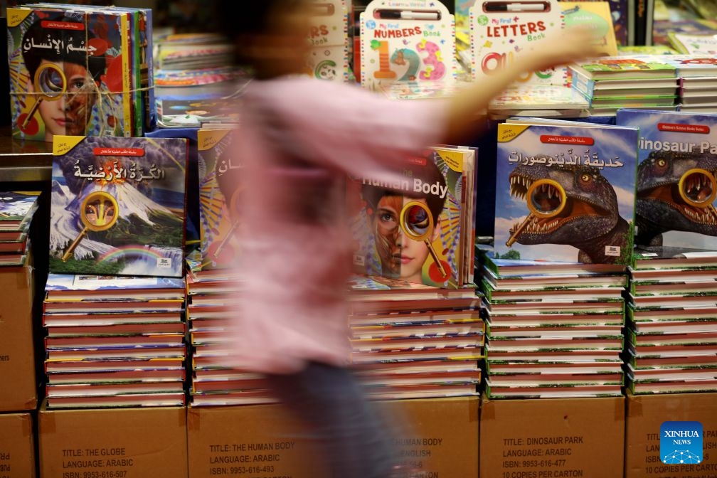 The photo taken on Oct. 11, 2026 shows a visitor walking past book shelves during the Beirut Arab International Book Fair in Beirut, Lebanon. (Photo: Xinhua)