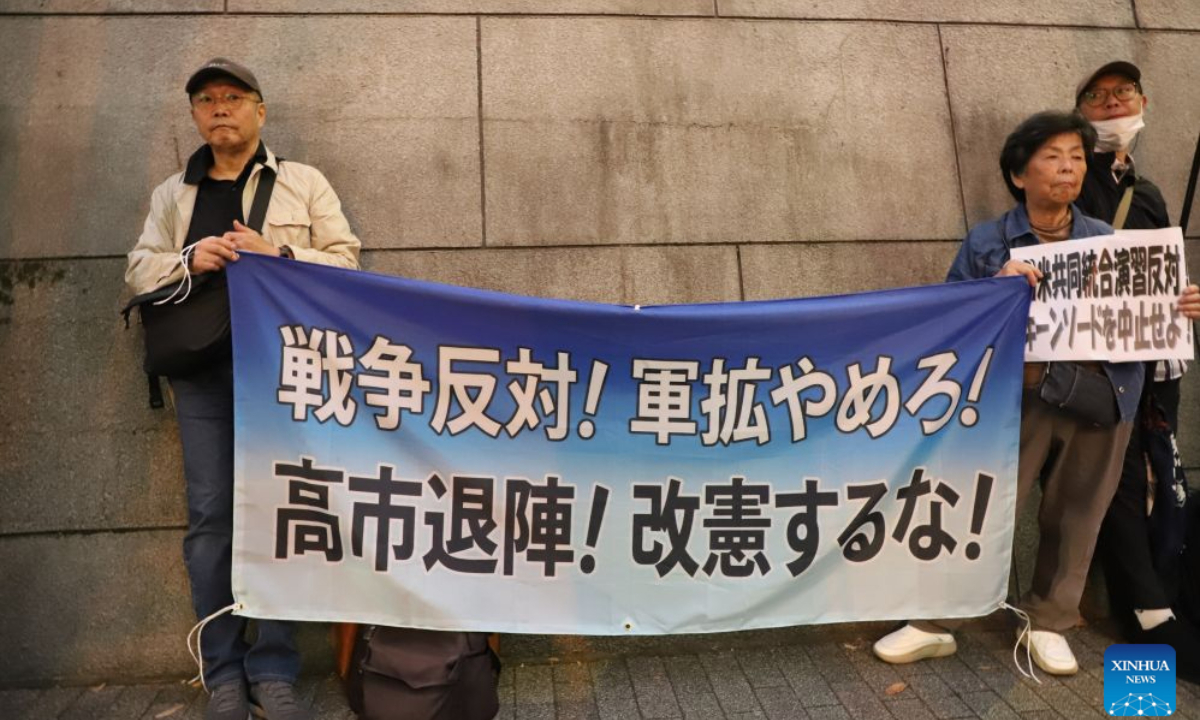 People holding signs attend a protest rally in Tokyo, Japan, Oct. 20, 2026. Japanese citizens staged a protest rally in front of the Ministry of Defense in Tokyo on Tuesday evening, opposing the large-scale Japan-U.S. joint military exercises and the military buildup. (Xinhua/Li Ziyue)