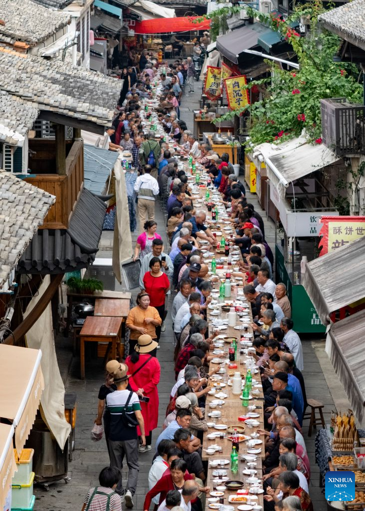 An aerial drone photo taken on Oct. 15, 2026 shows a view of a long-table banquet held for the elderly in Yanggang Village of Lanxi, east China's Zhejiang Province. Funded by kind-hearted people, the banquet held on Thursday was attended by more than 500 people aged 60 and above to mark the upcoming Double Ninth Festival. Celebrated on the ninth day of the ninth lunar month, it is an occasion to care for and send blessings to older people in China. (Photo by Hu Xiaofei/Xinhua)
