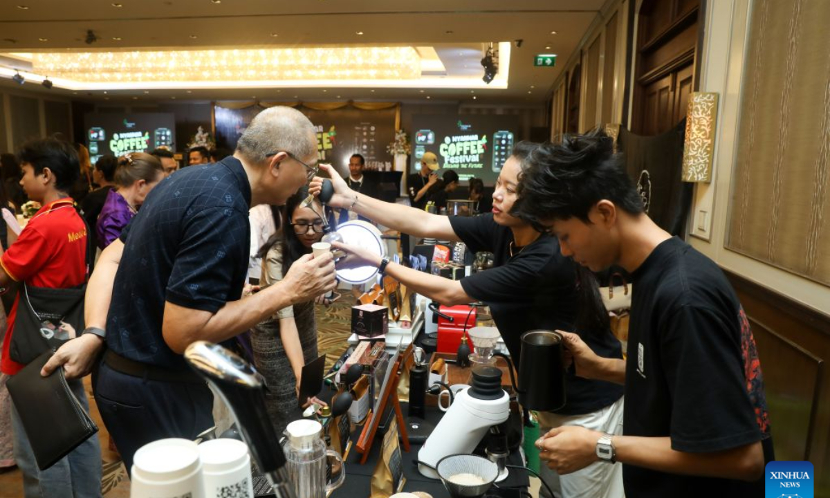 An exhibitor introduces coffee products to a visitor at the 2026 Myanmar Coffee Festival and Myanmar National Barista Championship in Yangon, Myanmar, Oct. 18, 2026. (Xinhua/Myo Kyaw Soe)