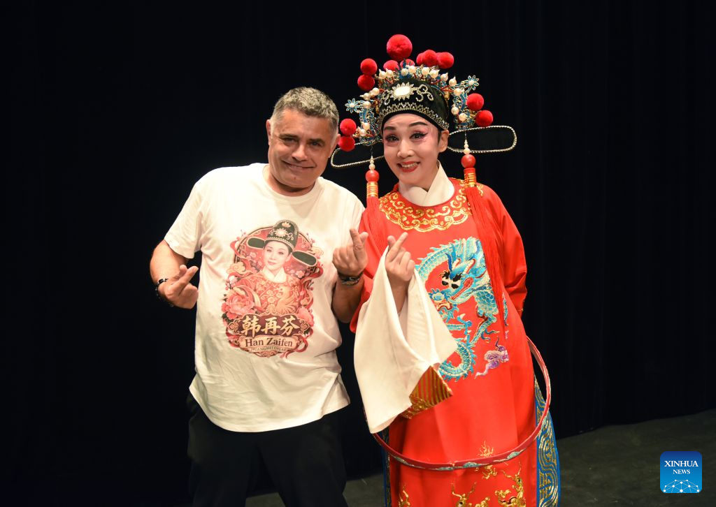 Chinese Huangmei Opera artist Han Zaifen (R) poses for photos with one of the local audience after a Huangmei opera performance in Vienna, Austria, Oct. 15, 2026. (Xinhua/He Canling)