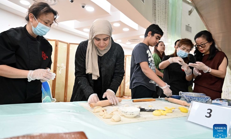 People participate in a Chinese culinary experience event in Hawalli Governorate, Kuwait, Oct. 13, 2026. Titled The Taste of China: Jiaozi (Dumpling) Experience, the event was organized by the China Cultural Center in Kuwait to introduce traditional Chinese food culture to local residents. More than 100 people participated in the event. (Photo: Xinhua)